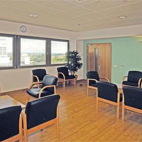 Inside a meeting room with chairs grouped around low tables