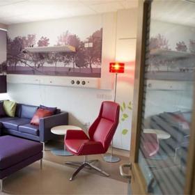 Room with chair, sofa, foot stool, side table and floor lamp.