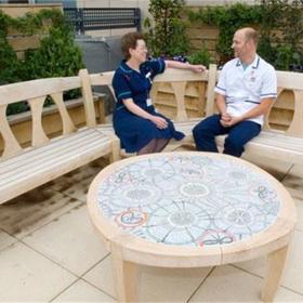A table inlaid with mosaic and a curved bench.