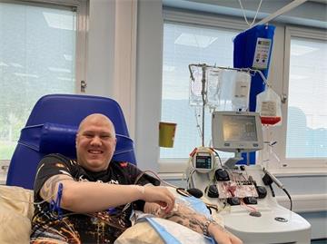 Man receives CAR-T cell therapy. He is sat down next to medical equipment