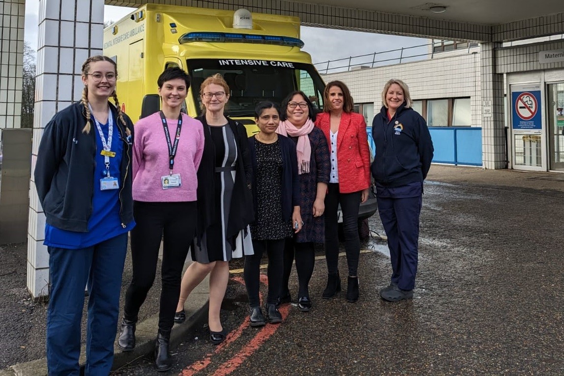Seven members of staff in front of an ambulance outside the "Women's Centre Maternity" entrance