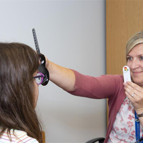 Adult doing an eye check on a young person