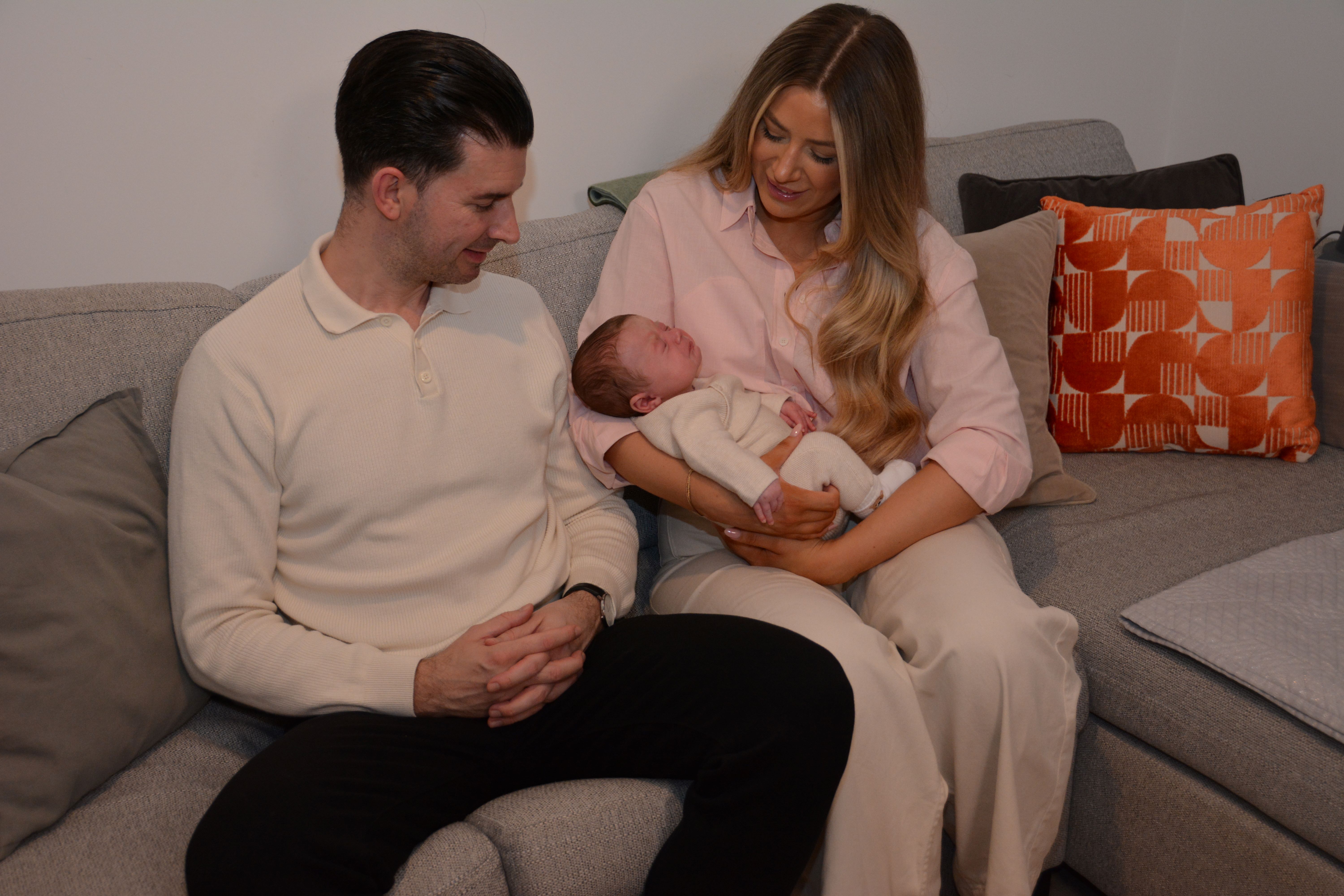 seated man and woman, with woman holding a baby