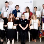 11 people in front of an 'Oxford University Hospitals' banner. 9 hold their certificates and awards.