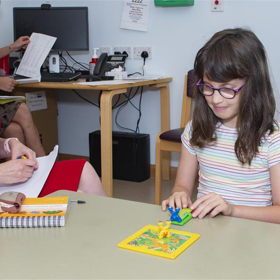 Adult observing a child doing a puzzle
