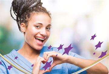 Smiling girl in scrubs makes a heart shape with her hands