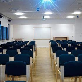 Interior of seminar room, set up with multiple rows of chairs facing the front