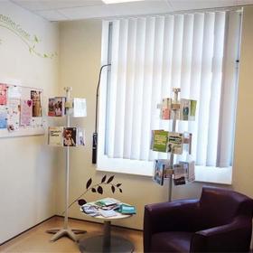 Room with chair, side table and leaflets.